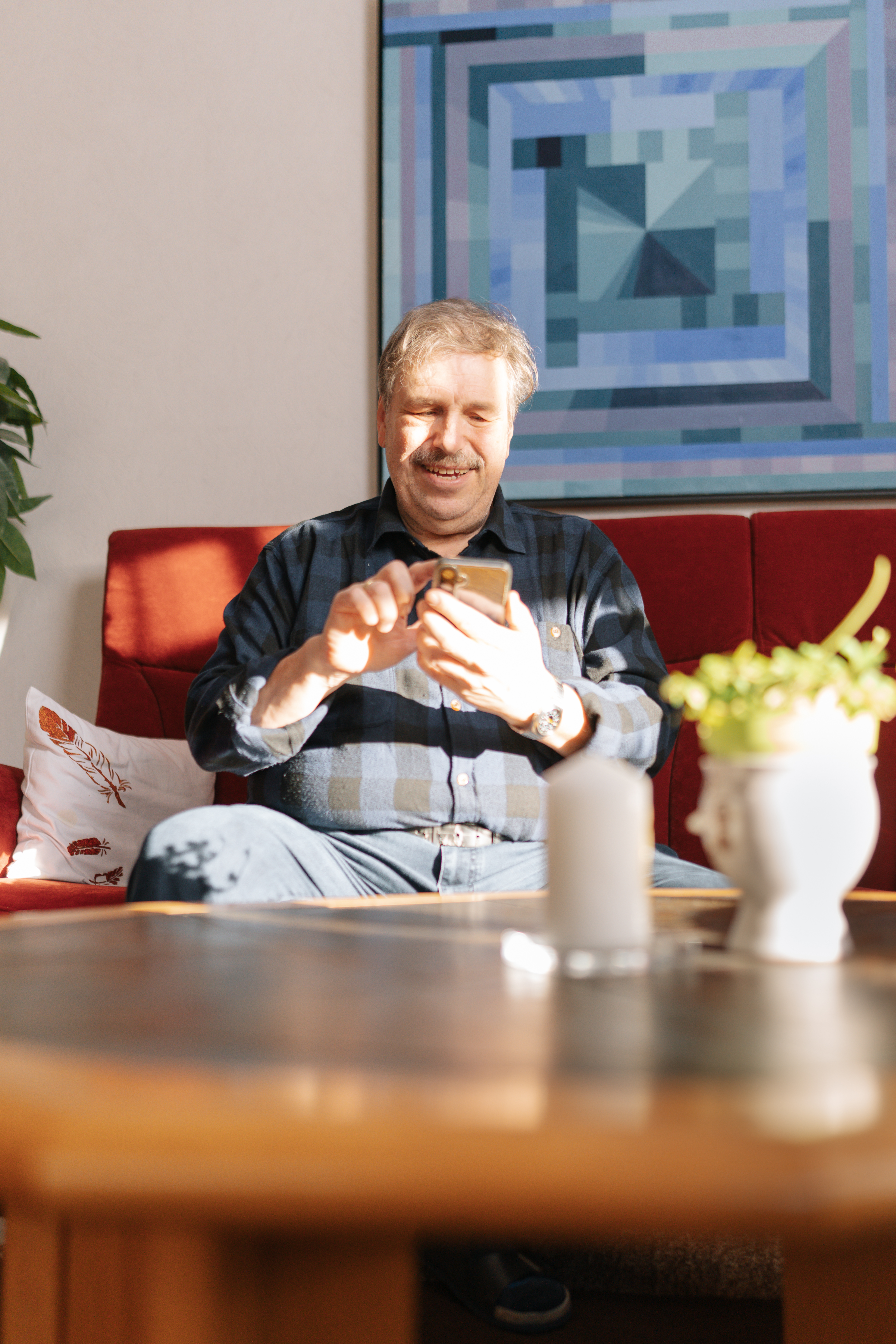 Hausbesitzer im Wohnzimmer beim Beratungsgespräch am Smartphone